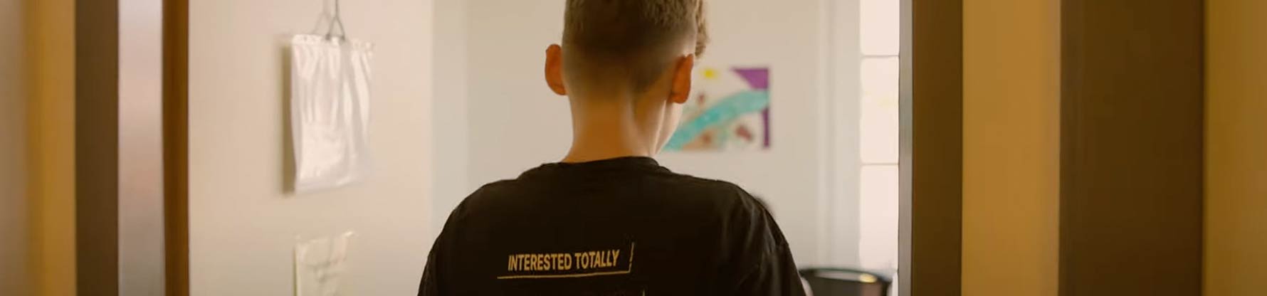 ein Junge in einem Zimmer von hinten